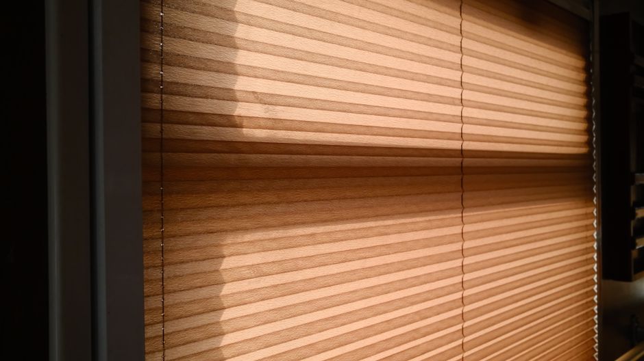 Sunlight filtering through natural wood blinds